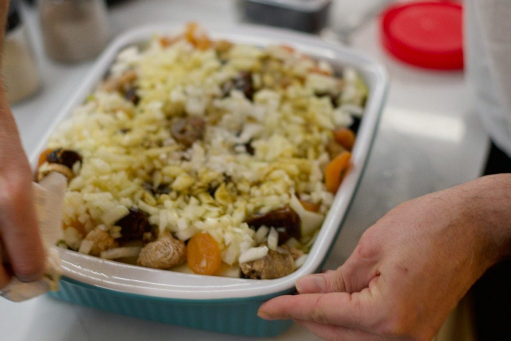a close up of a person putting food in a container