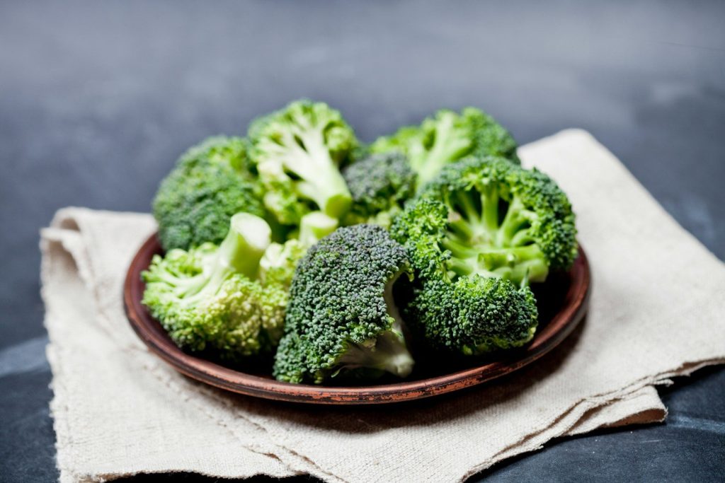 A plate of broccoli on a napkin on a table