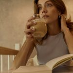 woman in white tank top drinking from clear drinking glass
