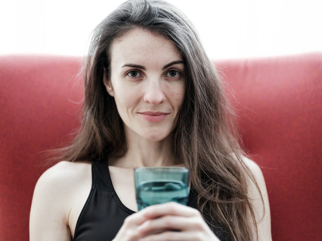 a woman sitting on a red chair holding a cell phone