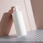 a hand holding a white bottle