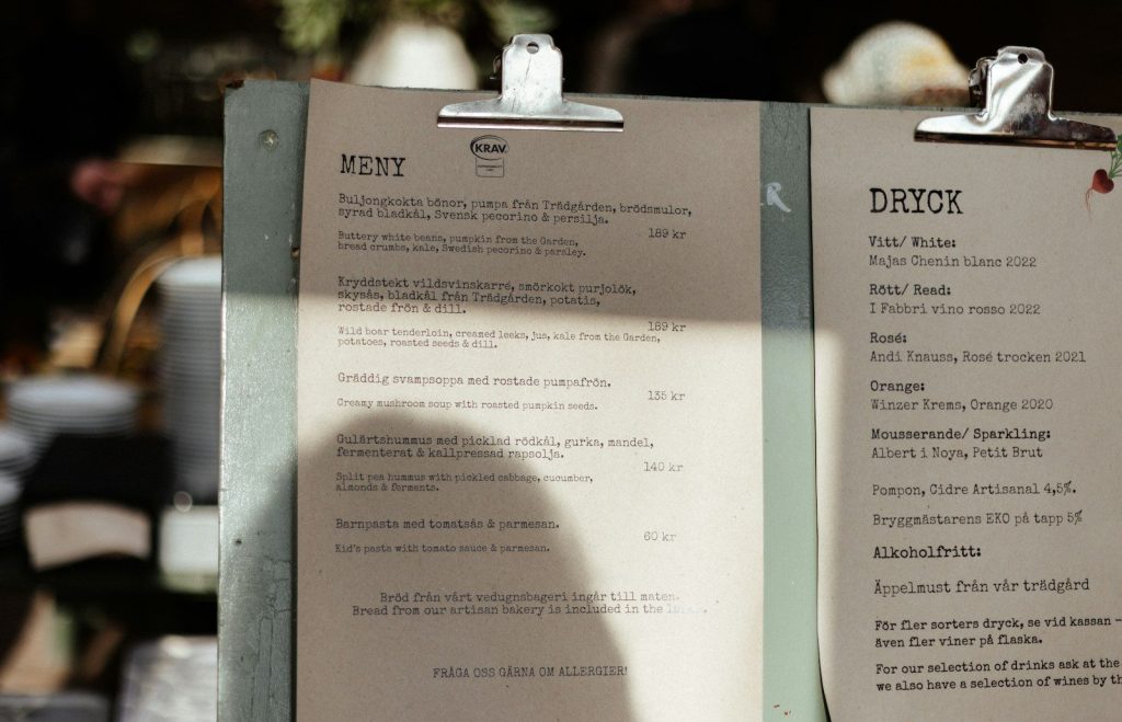 A menu sitting on top of a table next to a cup of coffee