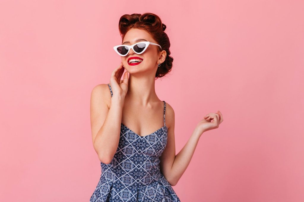 a woman in a blue dress and white sunglasses