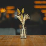 a vase of flowers sitting on top of a wooden table