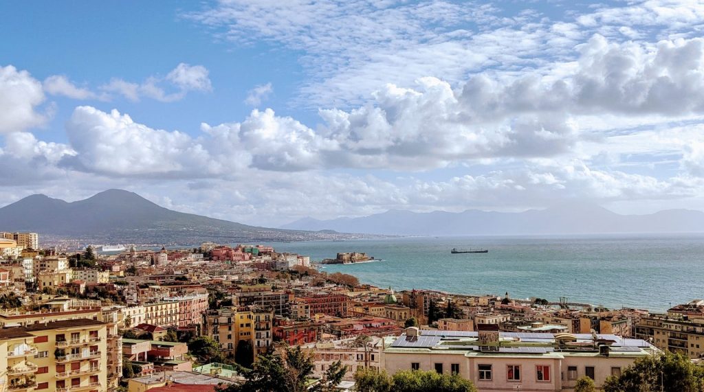 city buildings near sea under white clouds and blue sky during daytime