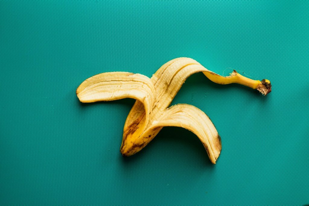 a peeled banana sitting on top of a green surface