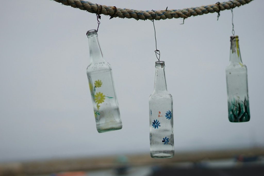 clear glass bottle hanging on brown rope