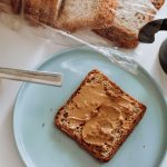a blue plate topped with a piece of bread and peanut butter