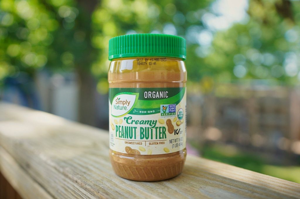 A jar of peanut butter sitting on top of a wooden table