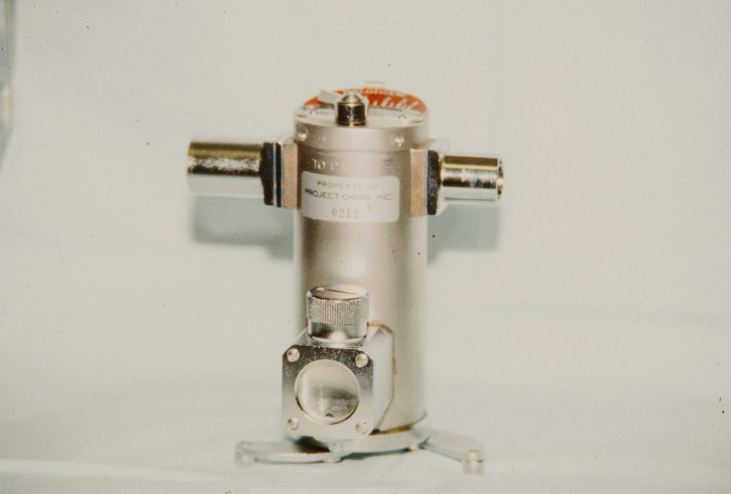 A metallic cylindrical object with two side connectors.