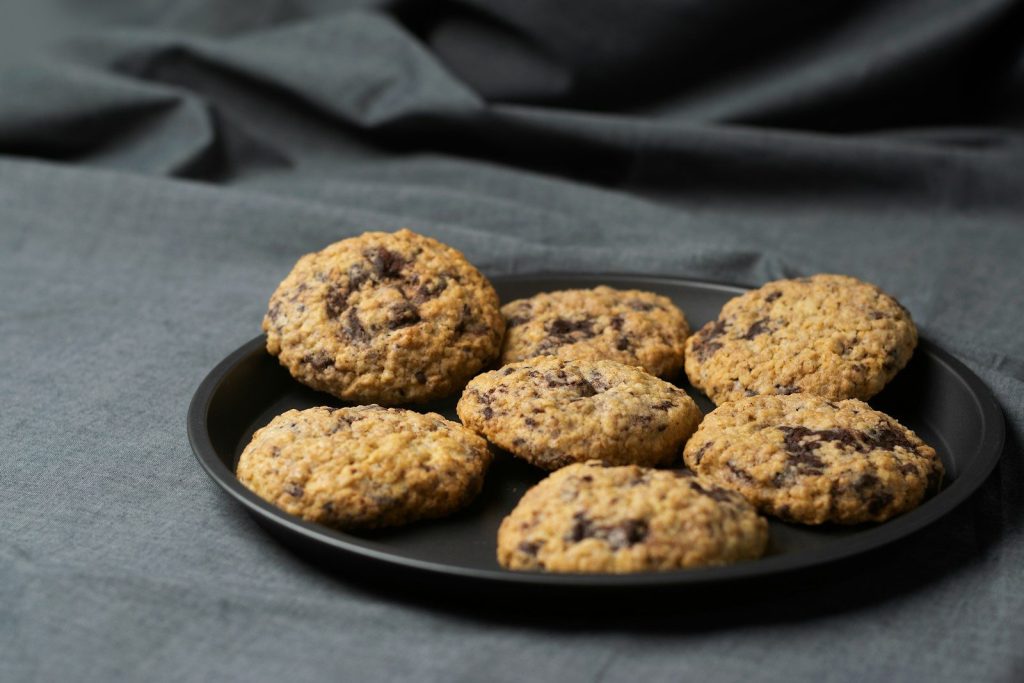 a plate of chocolate chip cookies on a gray cloth