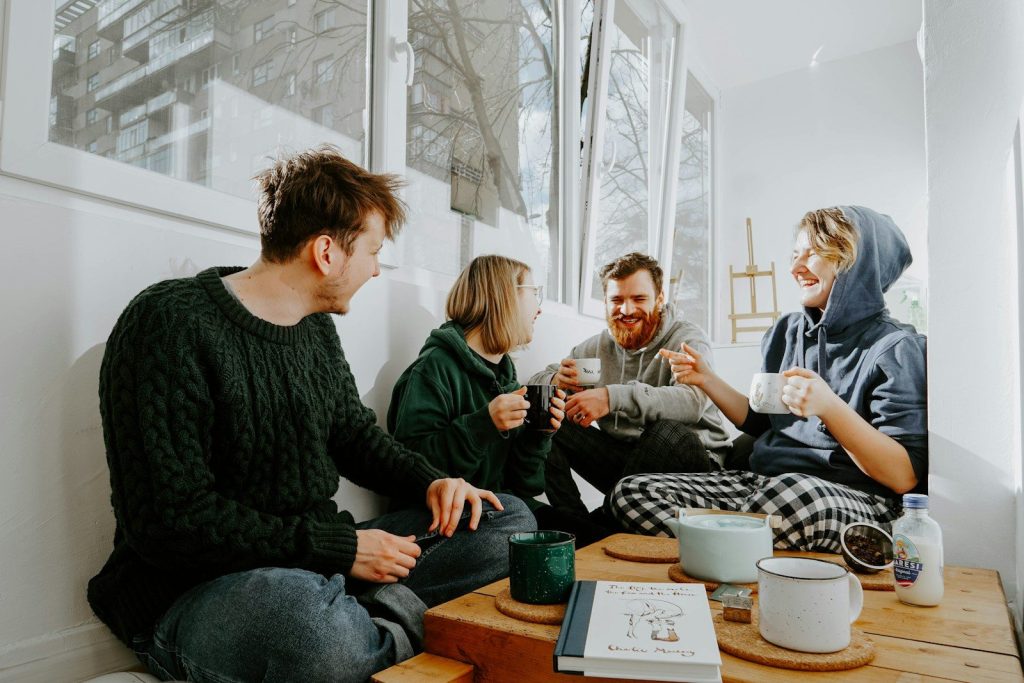 3 women and 2 men sitting on brown wooden table