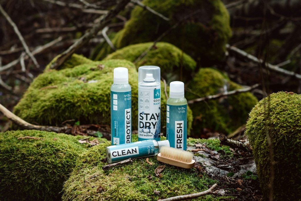a couple of bottles of deodorant sitting on top of a moss covered