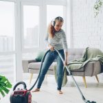 Woman vacuuming floor while listening to music.
