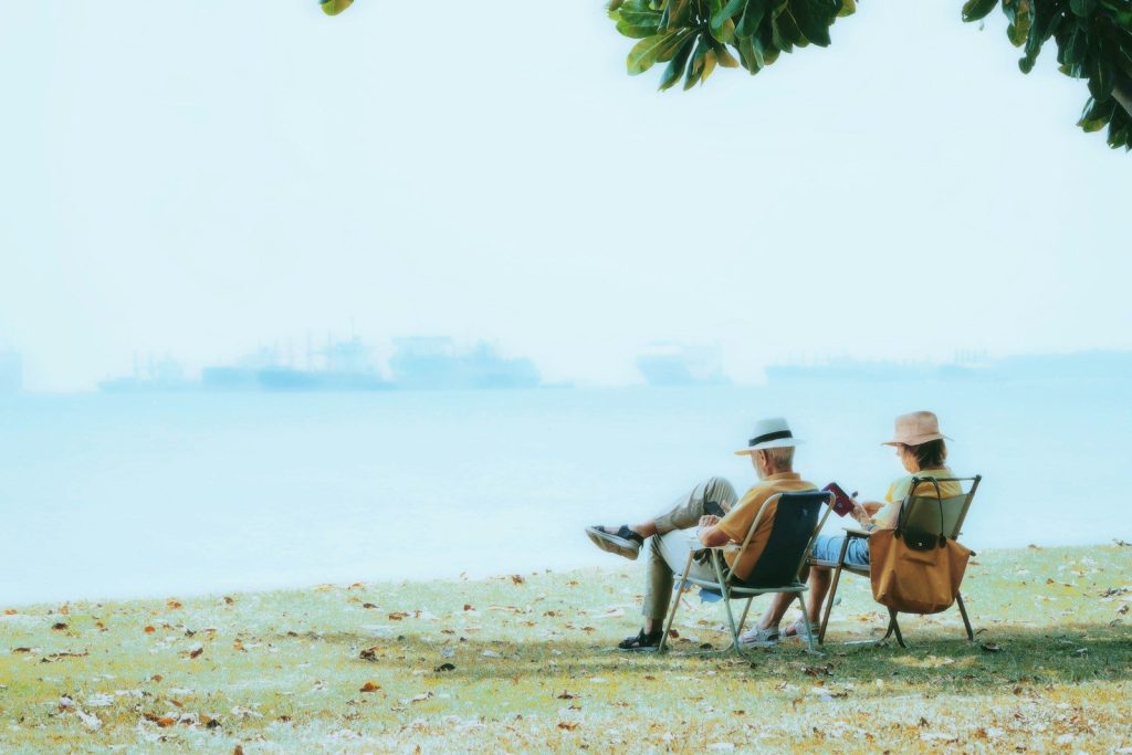Elderly couple relaxing by the ocean.
