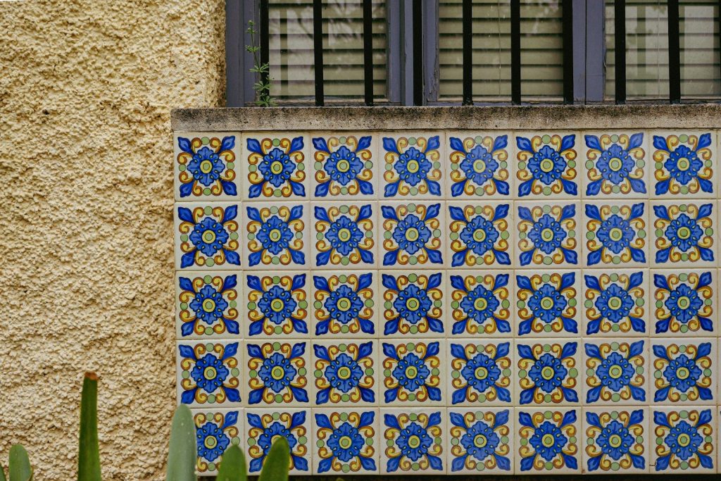 Decorative blue and yellow tiles on a textured wall.