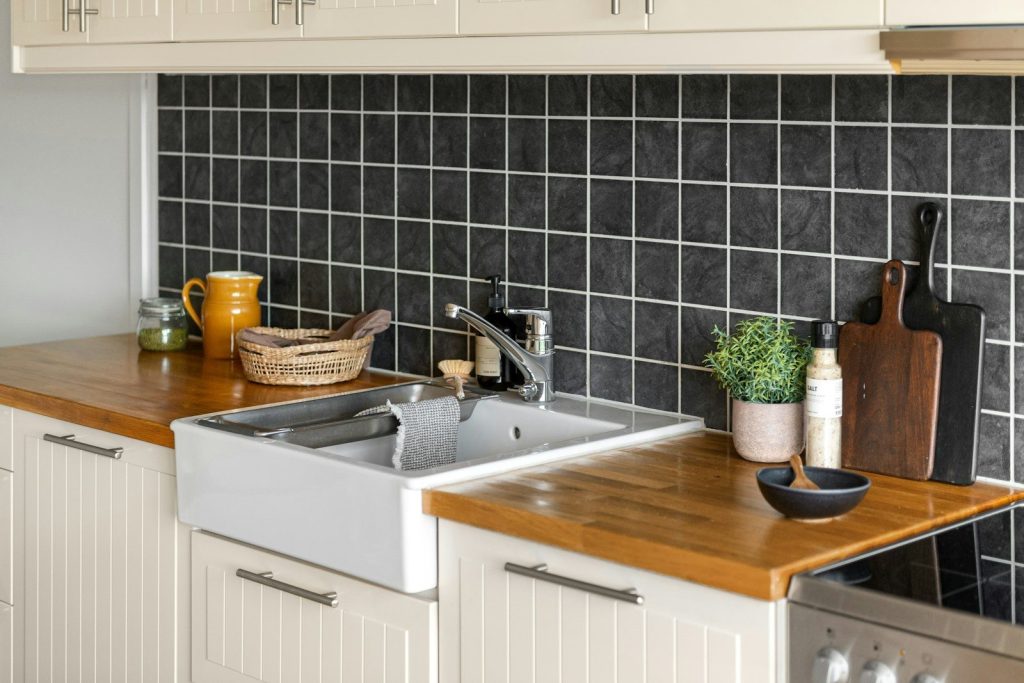 A kitchen with a sink, stove, dishwasher and cabinets