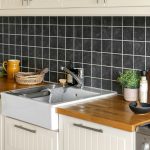 A kitchen with a sink, stove, dishwasher and cabinets