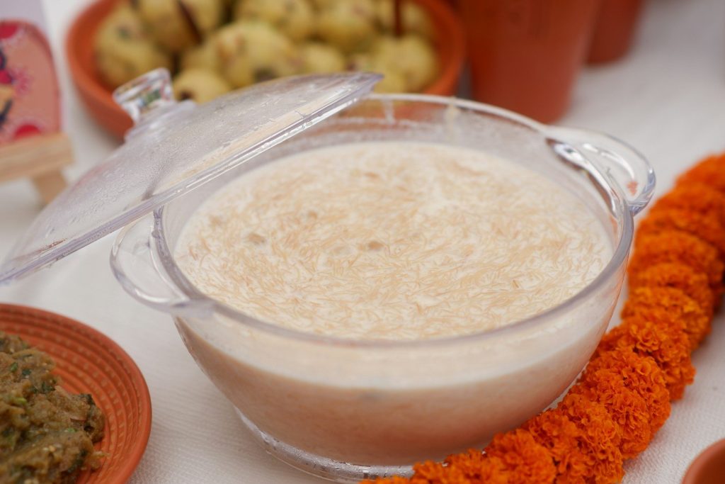 A bowl of creamy rice pudding with marigold garland