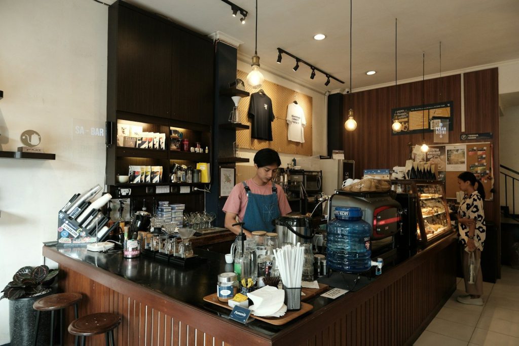 Barista preparing drinks behind a coffee shop counter.