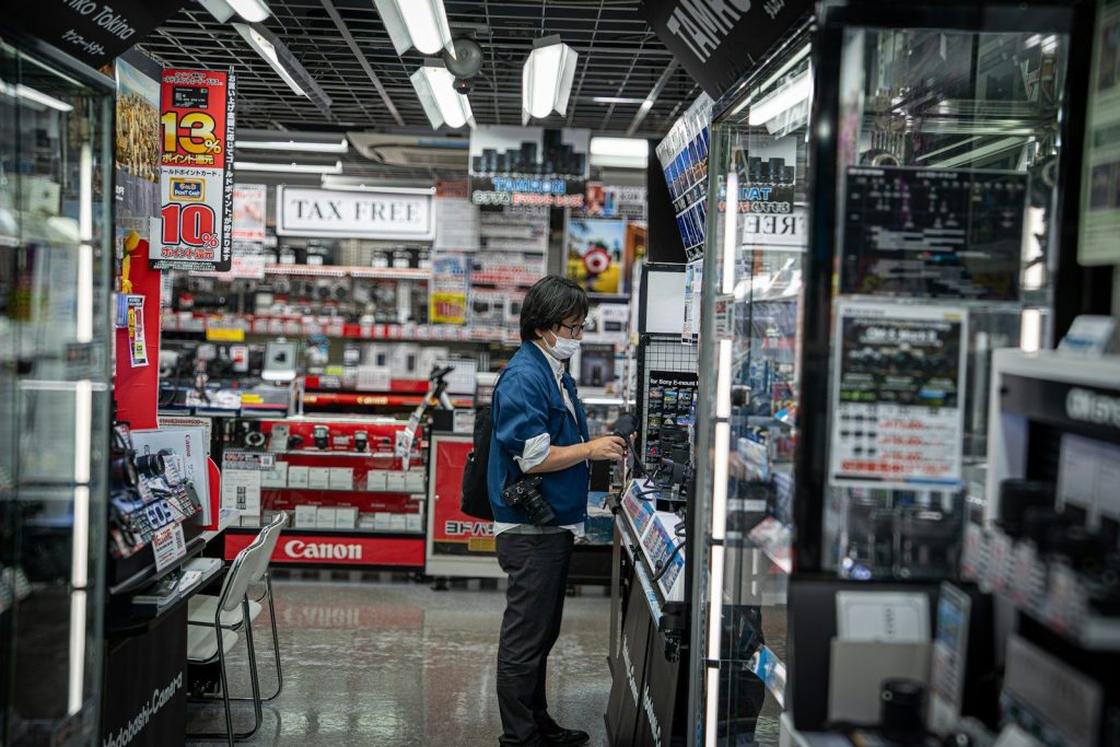 Person browsing electronics in a brightly lit store.