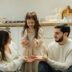 A group of people sitting around in a kitchen