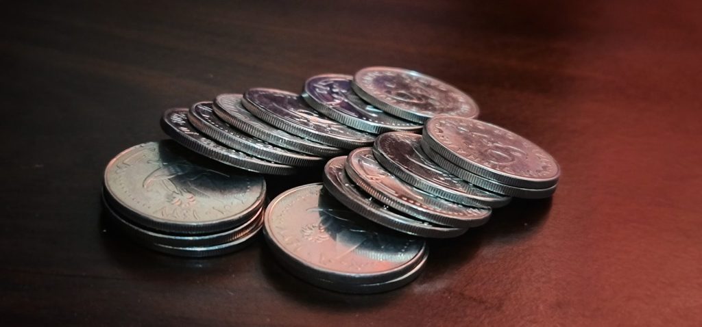 silver round coins on brown wooden table