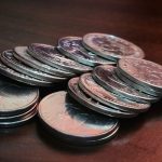 silver round coins on brown wooden table