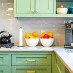 a kitchen with green cabinets and white counter tops