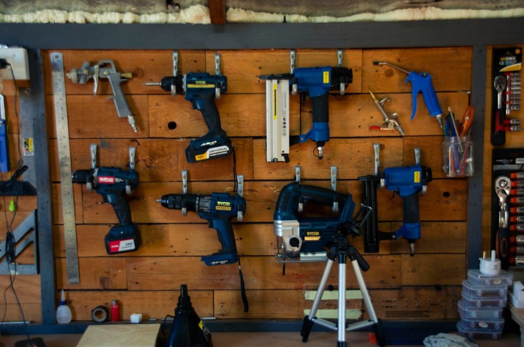 a wooden wall with tools hanging on it
