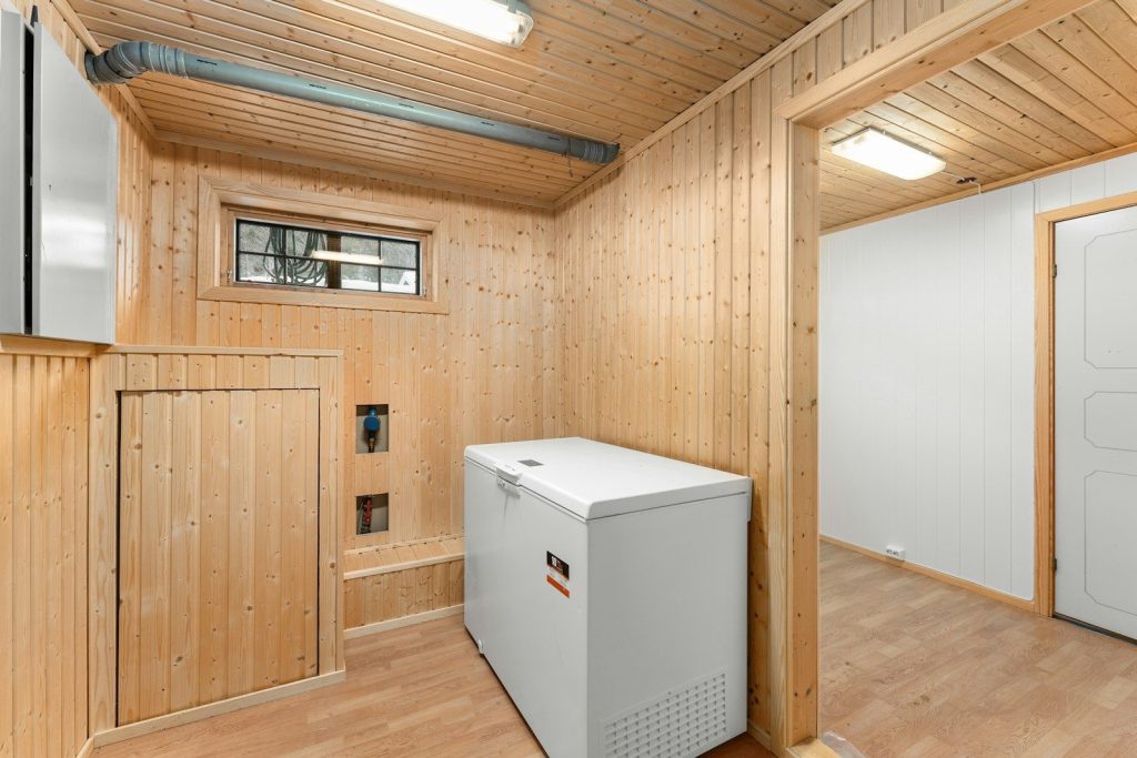 A room with wood paneling and a white refrigerator