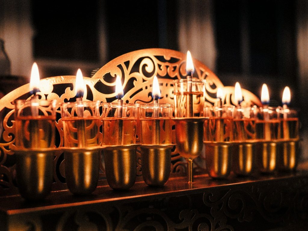 A row of lit candles sitting on top of a table