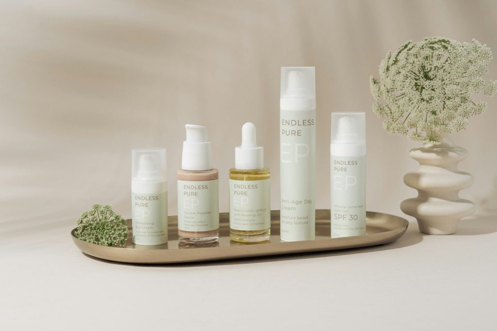 A tray with a bunch of bottles and a vase of flowers