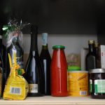 a shelf filled with lots of bottles and condiments