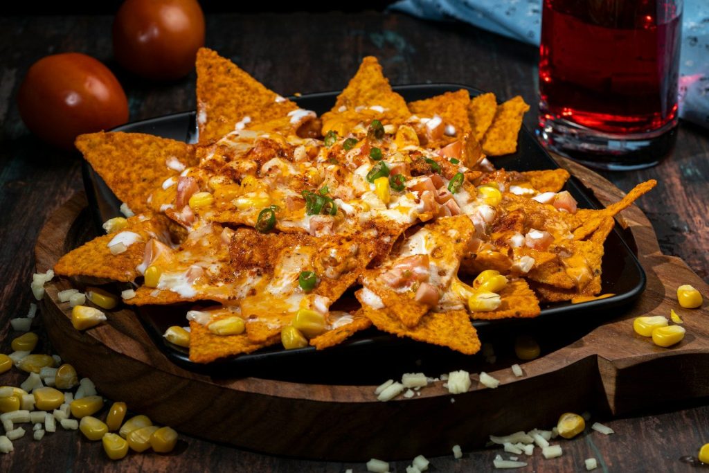 Nachos topped with cheese, corn, and herbs.