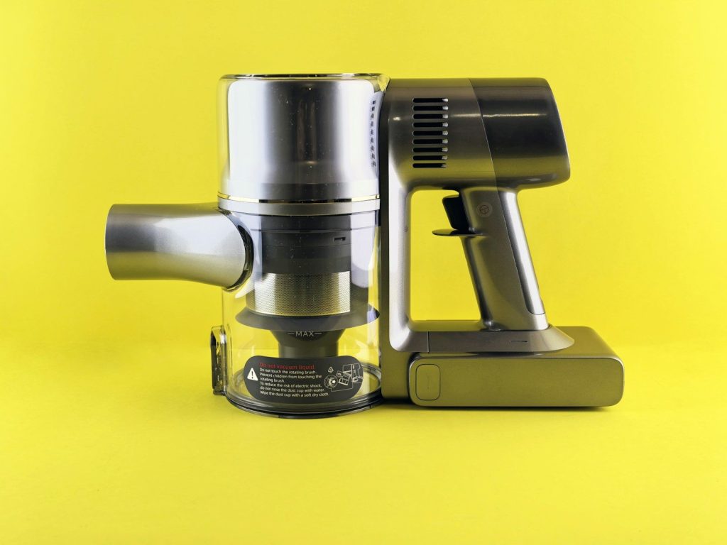 A modern cordless vacuum against a yellow backdrop.