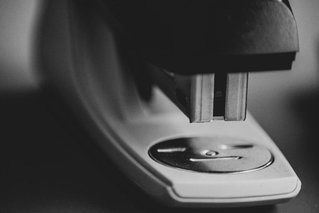 black and gray stapler on black surface