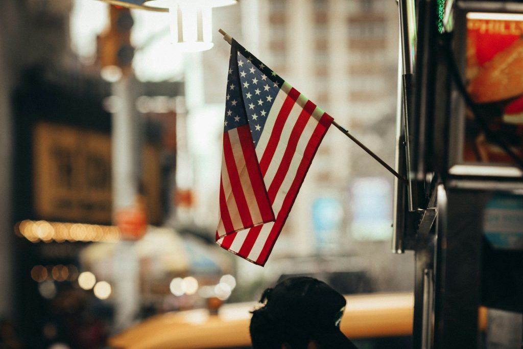 an american flag hanging from the side of a building