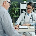 Doctor consulting with elderly man and child.