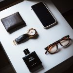 black framed eyeglasses beside black leather bifold wallet and black leather bifold wallet