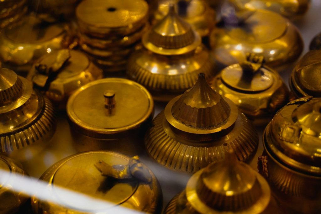 A collection of ornate golden containers with lids