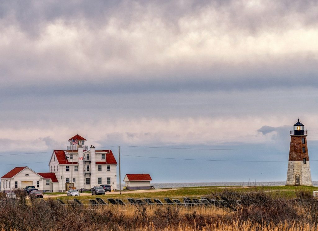 white and red house on green grass field under white clouds during daytime