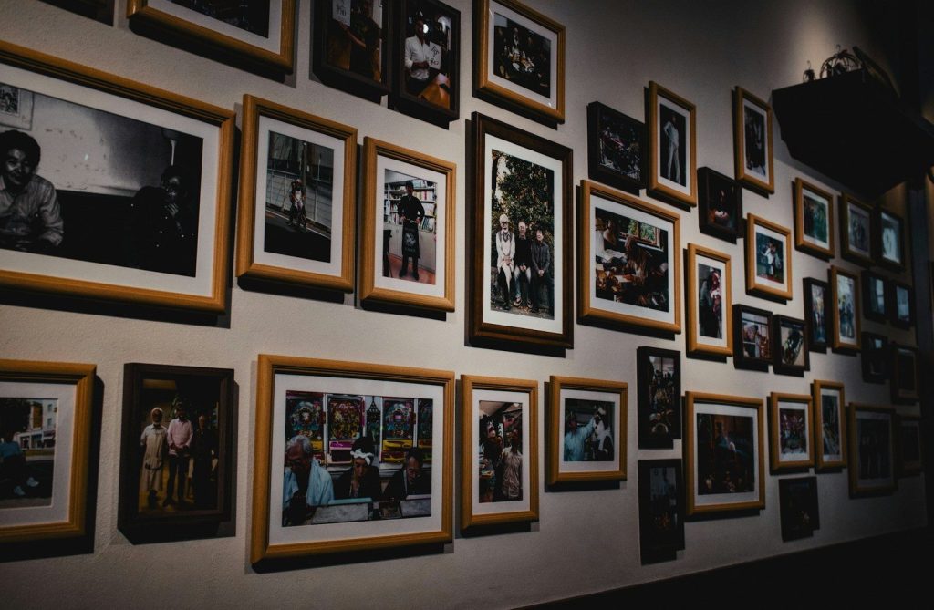 Numerous framed photographs hanging on a gallery wall.