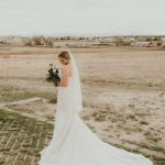 a woman in a wedding dress standing in a field
