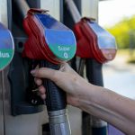 a person's hand is holding a gas pump