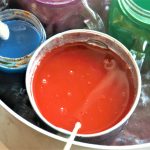 a bucket filled with paint next to another bucket filled with paint
