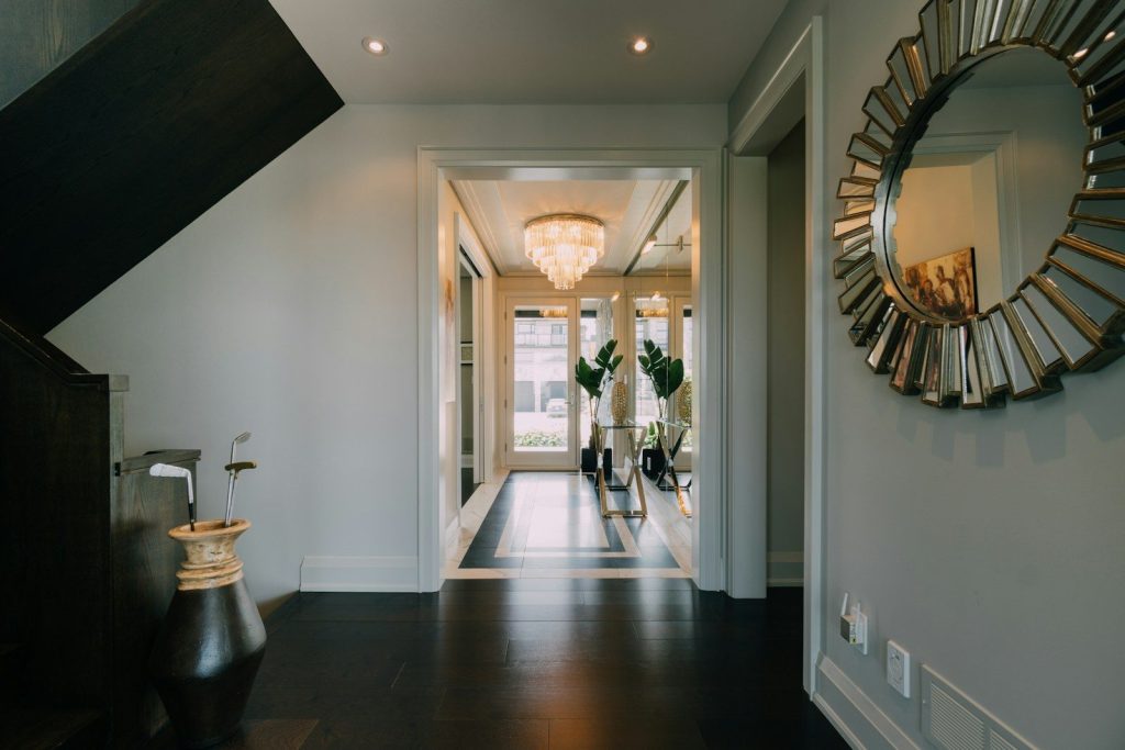 a hallway with a large mirror and a chandelier