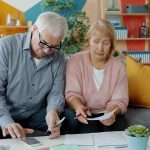 Elderly couple reviewing documents at home
