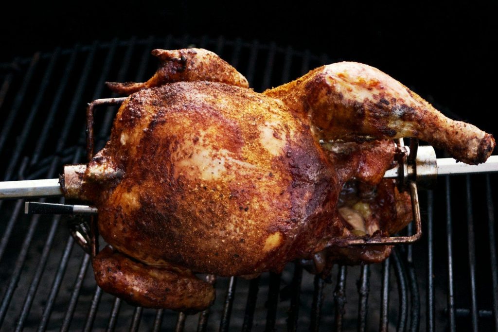 a whole chicken is cooking on a grill