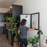 a woman standing in front of a refrigerator in a kitchen